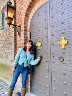 A photo of a woman standing by a large door